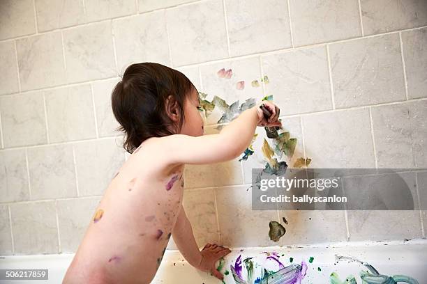 boy painting in bath. - baby bath stock-fotos und bilder