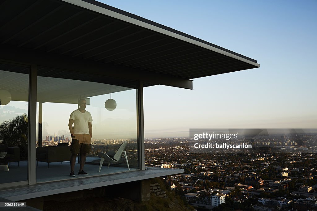 Man Standing In House Overlooking Los Angeles.