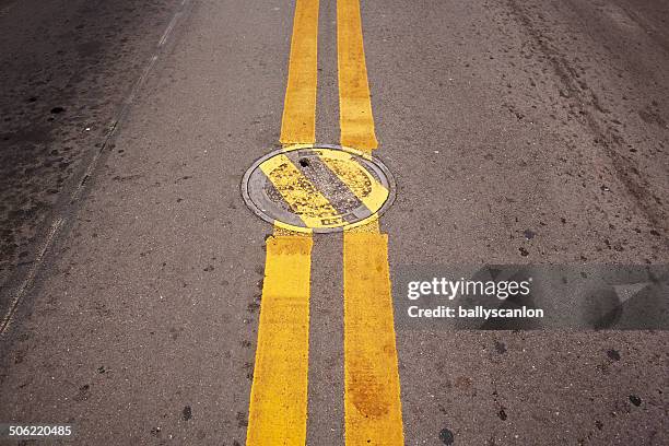 manhole cover with deviating lines. - linea gialla foto e immagini stock