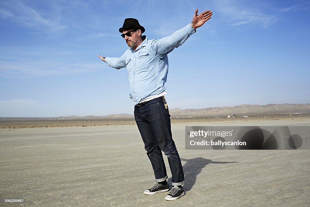 Man In Desert In High Wind.
