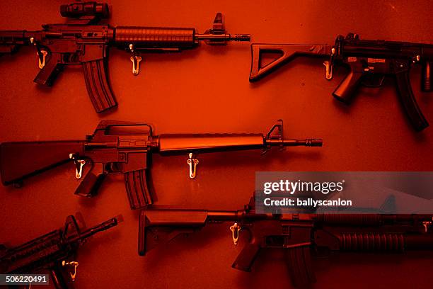 numerous assault rifles hanging on wall. - waffe stock-fotos und bilder