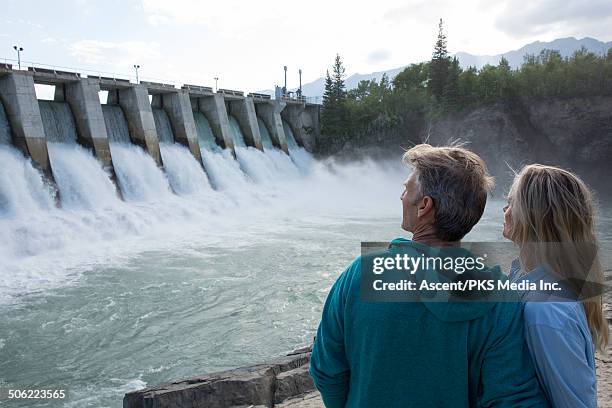 couple watch water spill form hydroelectric dam - hydroelectric power stock pictures, royalty-free photos & images