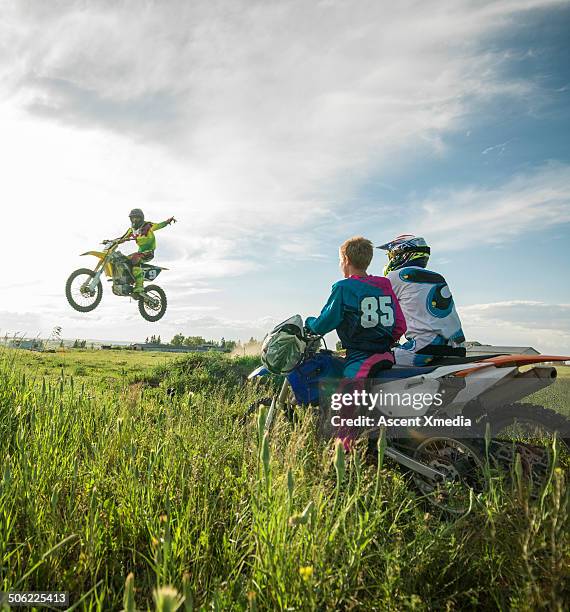 motocross rider jumps while family looks on - motocross imagens e fotografias de stock