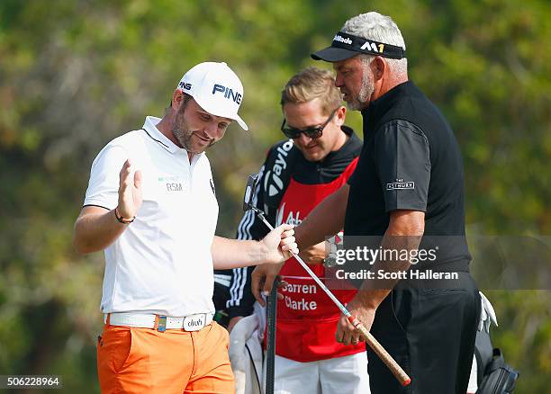 Andy Sullivan of England acknowledges the crowd after a birdie on the 10th hole as Darren Clarke of Northern Ireland looks on during the second round...