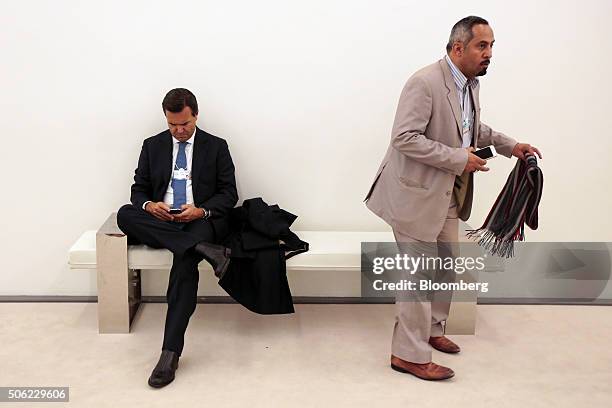 Antonio Horta-Osorio, chief executive officer of Lloyds Banking Group Plc, left, browses his smartphone device between sessions during the World...