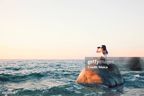 looking with binoculas on top of a bouder - girl stare stock pictures, royalty-free photos & images
