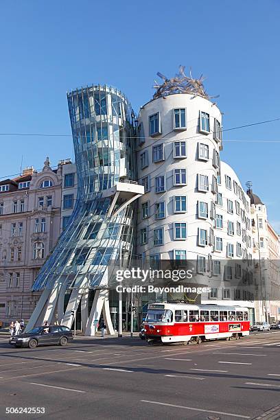 old prague tram passing famous dancing house - tancici dum stock pictures, royalty-free photos & images
