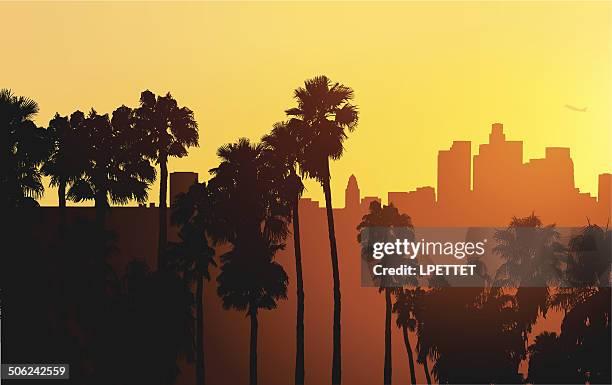 silhouette of downtown los angeles at sunset with palm trees - downtown stock illustrations