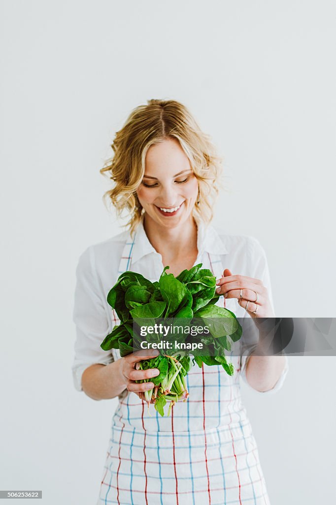 Junge Frau mit frischem Spinat