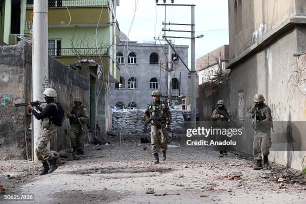 Turkish security forces patrol at a street blocked and heavily damaged by PKK terrorists during a counter - terrorism operation against terrorist...