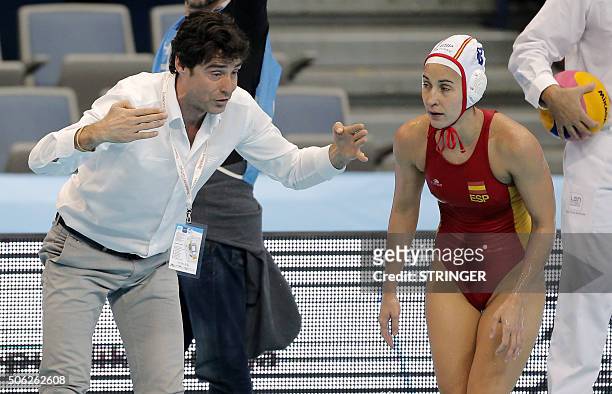 Spain's national water polo team head coach Miguel Oca speaks with Maria Pena Del Pilar during the women's water polo bronze medal match between...