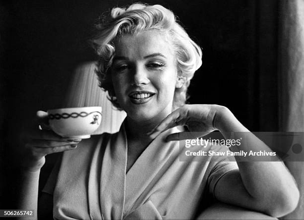 Marilyn Monroe poses with a coffeee cup in a room at the Hotel St. Regis in 1954 in New York, New York.
