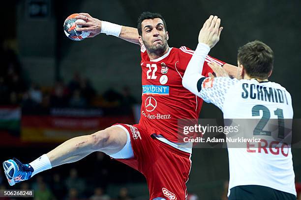 Iman Moorchegani Jamali from Hungary throws the ball against Erik Schmidt from Germany during the Men's EHF Handball European Championship 2016 match...