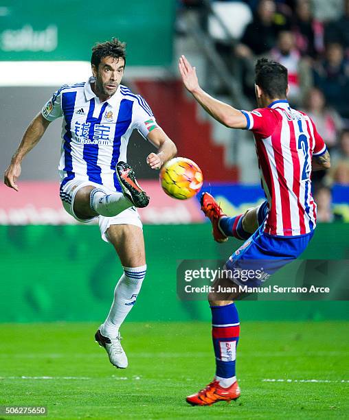 Xabier Prieto of Real Sociedad duels for the ball with Luis Hernandez of Real Sporting de Gijon during the La Liga match between Real Sporting de...