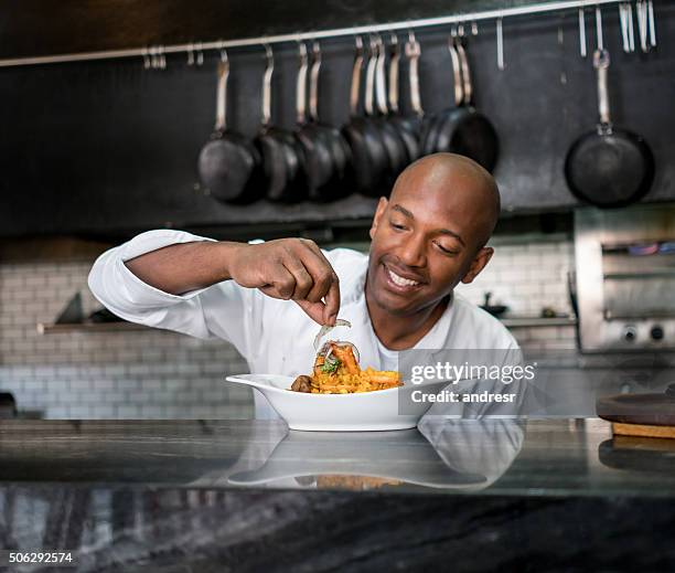 chef decorating a plate - catering black uniform stockfoto's en -beelden