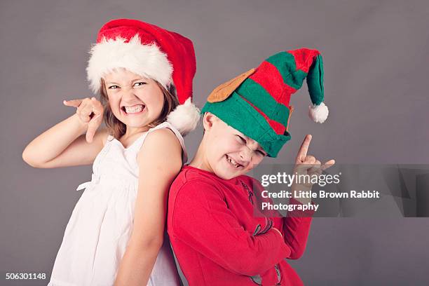 siblings wearing hats at christmas - spoilt children stock-fotos und bilder