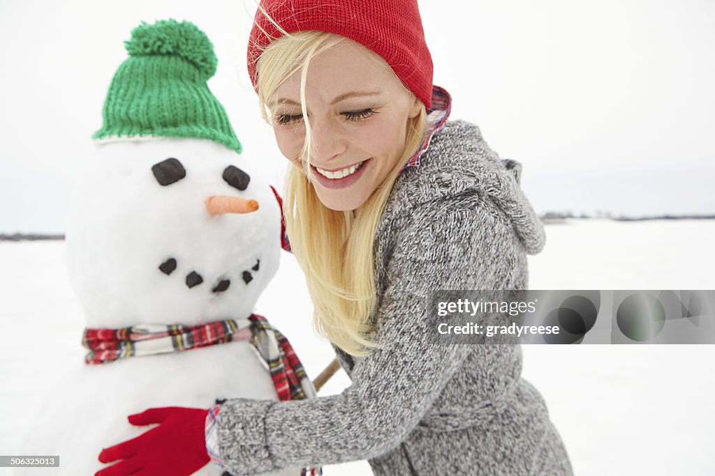 Making sure that her snowman looks perfect