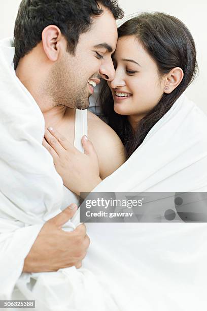 atractiva pareja en la cama haciendo romance. - pareja abrazados cama fotografías e imágenes de stock