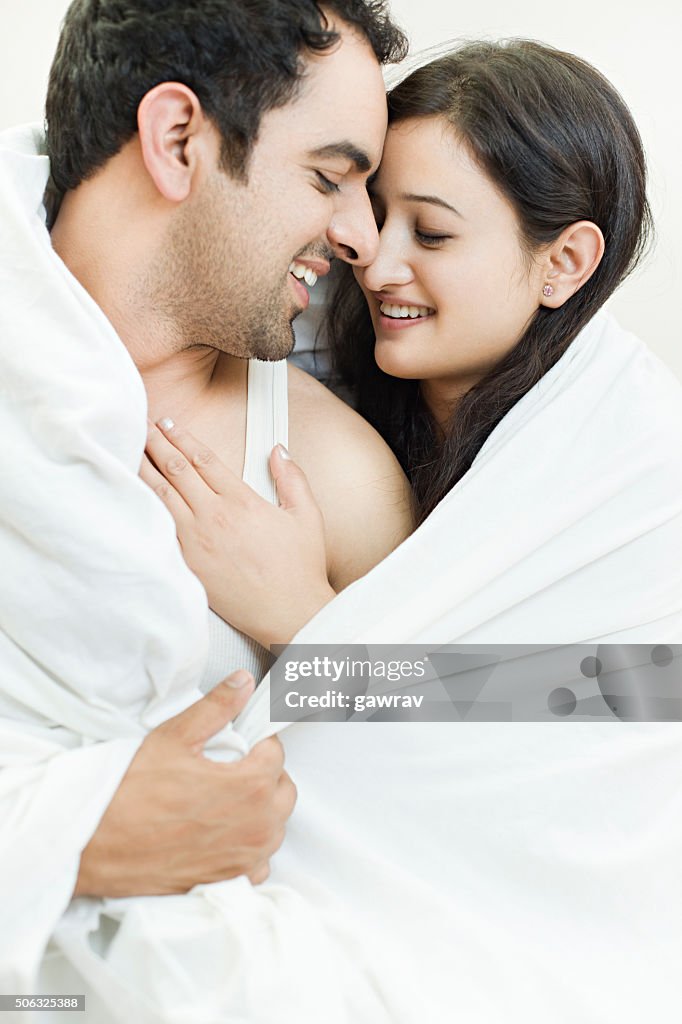 Attractive couple together on bed doing romance.