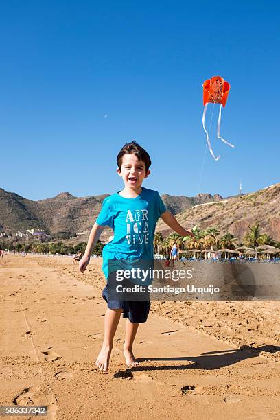 boy flying a kite on the beach - playa de las teresitas stock pictures, royalty-free photos & images