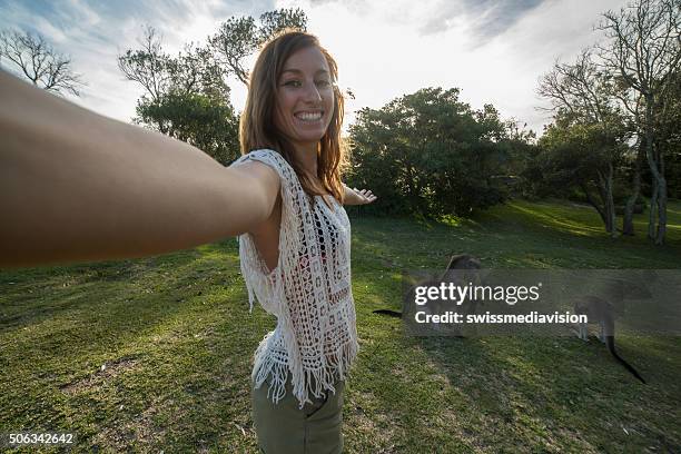 woman in australia takes selfie portrait with kangaroos on background - kangaroo jump stock pictures, royalty-free photos & images