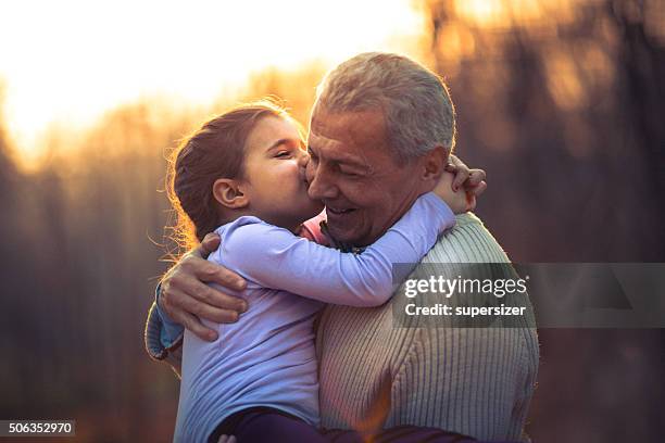 photo of grandfather and his granddaughter in the park - granddaughter stock pictures, royalty-free photos & images