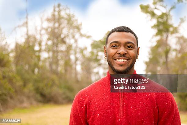 handsome, confident african descent young man outdoors in autumn. - red cardigan sweater stock pictures, royalty-free photos & images