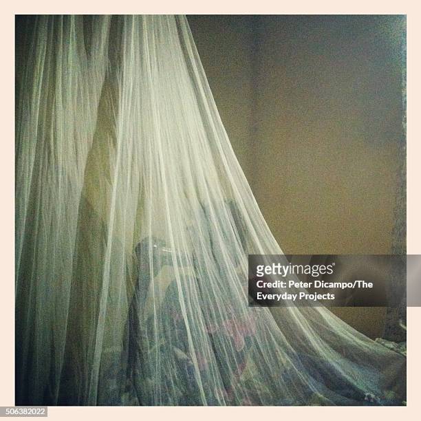 Rose Nangoba drinks a Coca-Cola under a mosquito net soon after giving birth in a rural clinic in Naigobya, Uganda on May 23, 2012.