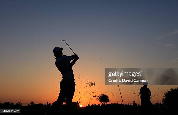 Rory McIlroy plays his second shot at the par 4, ninth hole as the sun sets during the third round of the 2016 Abu Dhabi HSBC Golf Championship at...