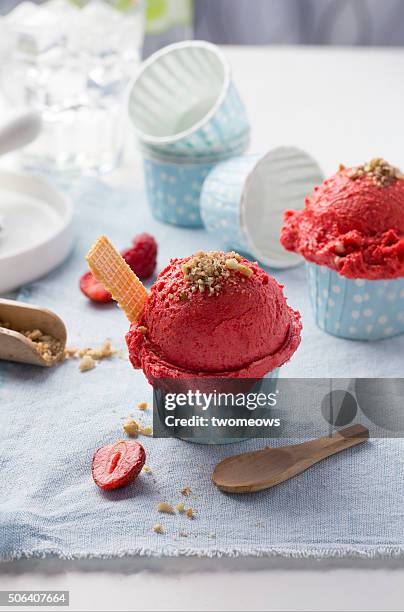 strawberry ice cream with peanut topping on white table top background. - ice cream cup stock-fotos und bilder