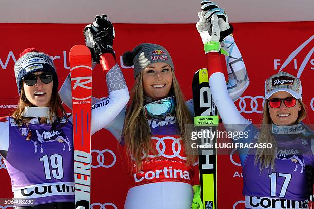 Winner US Lindsey Vonn celebrates on the podium next to Canada's Larisa Yurkiw , second, and Swiss Lara Gut, third, after the FIS Alpine Skiing World...