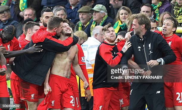 With his shirt off, Liverpool's English midfielder Adam Lallana celebrates scoring their late winning goal with teammates and Liverpool's German...