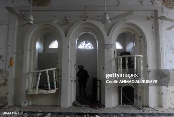 An Iraqi policeman checks the damage at a Sunni mosque that was destroyed during violence earlier in the month in the town of Muqdadiyah, northeast...