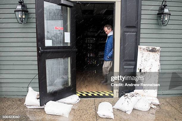 Jim Hand, owner of Fred's Tavern and Liquor Store, lets water out of his store after it floodedduring a blizzard January 23, 2016 in Stone Harbor,...