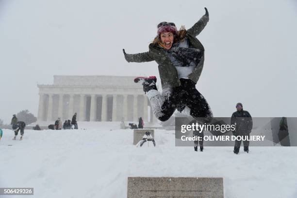 People play in the snow in front of the Lincoln memorial during a major storm on January 23, 2016 in Washington. - A deadly blizzard with...