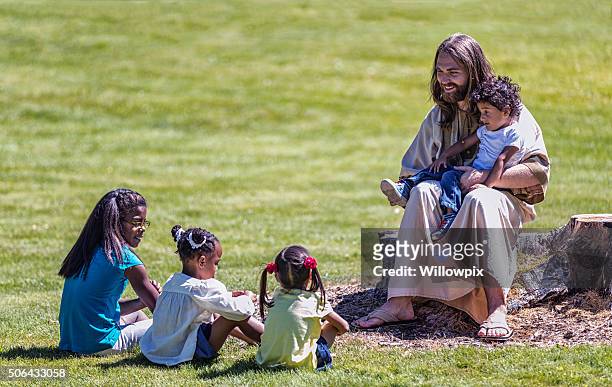 jesus christ sitting teaching four children siblings - jesus christ stock pictures, royalty-free photos & images