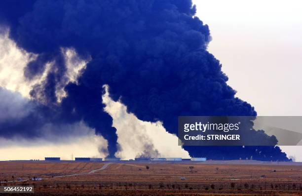 Heavy black smoke rises an oil facility in northern Libya's Ras Lanouf region on January 23 after it caught fire following attacks launched by...