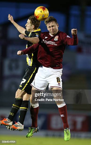 Joel Byrom of Northampton Town contests the ball with Andy Fleming of Morecambe during the Sky Bet League Two match between Northampton Town and...