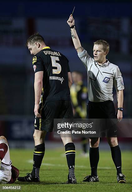 Referee Gavin Ward shows a yellow card to Adam Dugdale of Morecambe during the Sky Bet League Two match between Northampton Town and Morecambe at...