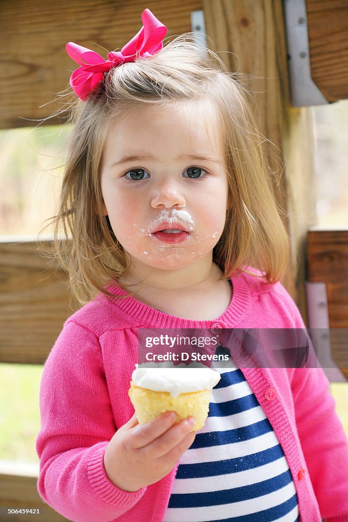 Young girl eating cupcake