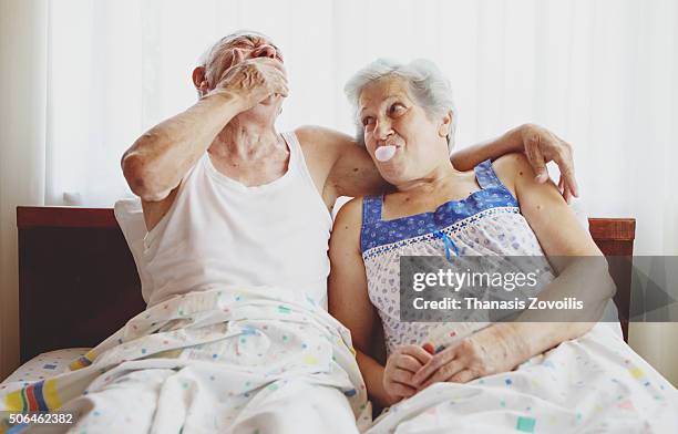 senior woman blowing a gum - old bed stockfoto's en -beelden