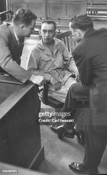 Denver University law students Harry Anderson and Donald Gallion talking with their client Joseph Springer during the trial.