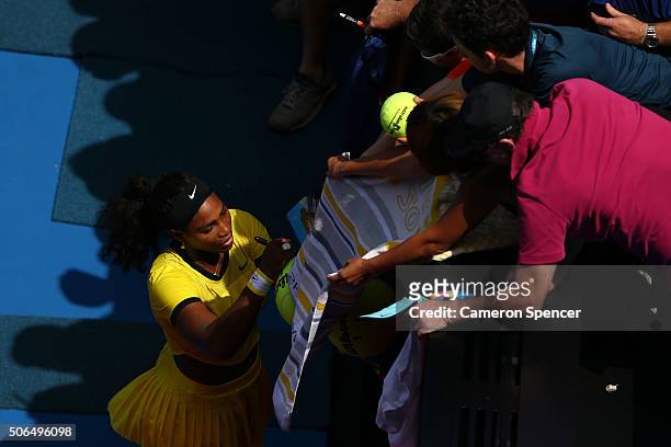 Serena Williams of the United States signs autographs for fans after winning her fourth round match against Margarita Gaspatryan of Russia during day...