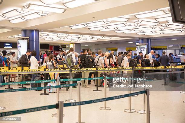 travelers waiting in line to pass through airport security  rr - security pass stockfoto's en -beelden