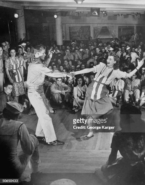 Actress Dorothy McGuire w. Amer. Soldier doing the Lindy in front of onlooking servicemen & gals at the American Theater Wing's Stage Door Canteen in...