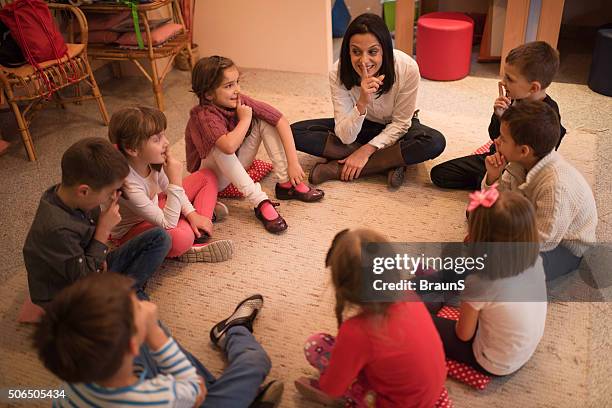 preschool teacher playing leisure games with group of children. - children circle floor stock pictures, royalty-free photos & images