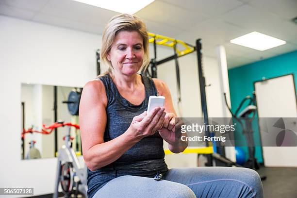 diabetic patient testing her blood sugar in a gym - blood sugar test stock pictures, royalty-free photos & images