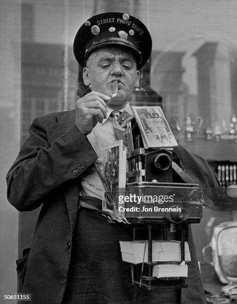Famed news photographer Weegee aka Arthur Fellig lighting up a cigar while hamming it up as a street-cameraman for the movie Every Girl Should Be...