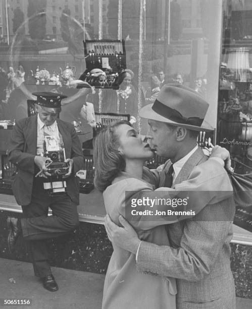 Famed news photographer Weegee aka Arthur Fellig , as a street-cameraman, honing in on actors Betsy Drake & Franchot Tone during their kiss for the...