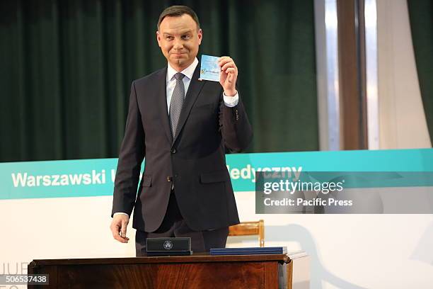 Polish President Andrzej Duda presents his signed organ donation card at the 50th anniversary symposium of the first successful kidney transplant in...